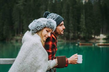Hübsches Paar junger Erwachsener beim Besuch eines Bergsees in Prags, Italien - Touristen in Wanderkleidung haben Spaß im Urlaub während des Herbstlaubs - Konzepte über Reisen, Lebensstil und Fernweh - DMDF01287