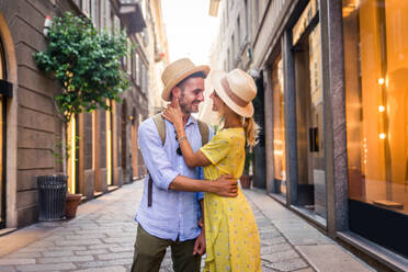 Beautiful couple of lovers shopping in the city centre - Playful tourists visiting a famous european city - DMDF01322