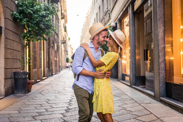 Beautiful couple of lovers shopping in the city centre - Playful tourists visiting a famous european city - DMDF01325