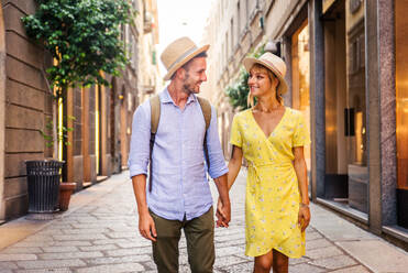 Beautiful couple of lovers shopping in the city centre - Playful tourists visiting a famous european city - DMDF01328