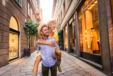 Beautiful couple of lovers shopping in the city centre - Playful tourists visiting a famous european city - DMDF01331