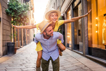 Beautiful couple of lovers shopping in the city centre - Playful tourists visiting a famous european city - DMDF01335