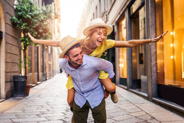 Beautiful couple of lovers shopping in the city centre - Playful tourists visiting a famous european city - DMDF01336