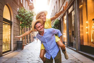 Beautiful couple of lovers shopping in the city centre - Playful tourists visiting a famous european city - DMDF01337