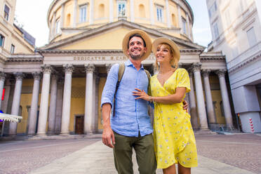 Beautiful couple of lovers sightseeing a famous landmark - Playful tourists visiting a famous european city - DMDF01343