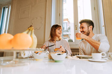 Two young adults at home - Beautiful couple of lovers having breakfast in the morning - DMDF01371