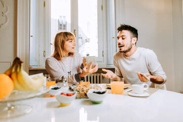 Two young adults at home - Beautiful couple of lovers having a discussion about betrayal with smartphone - DMDF01373