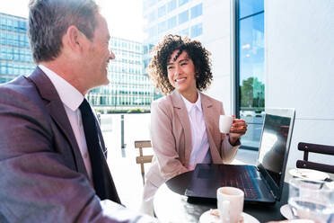 Senior businessman and beautiful hispanic businesswoman meeting in a bar restaurant - Two colleagues bonding in a cafe after work - DMDF01407