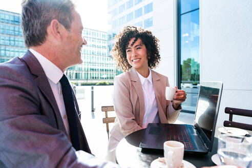 Senior businessman and beautiful hispanic businesswoman meeting in a bar restaurant - Two colleagues bonding in a cafe after work - DMDF01407