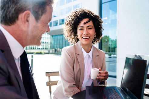 Senior businessman and beautiful hispanic businesswoman meeting in a bar restaurant - Two colleagues bonding in a cafe after work - DMDF01408