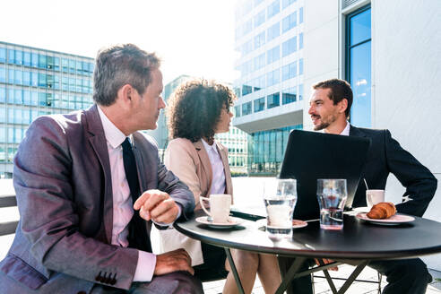 Senior businessman, caucasian man and beautiful hispanic businesswoman meeting in a bar restaurant - Three colleagues bonding in a cafe after work - DMDF01410