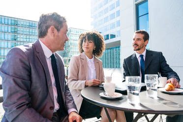 Senior businessman, caucasian man and beautiful hispanic businesswoman meeting in a bar restaurant - Three colleagues bonding in a cafe after work - DMDF01411