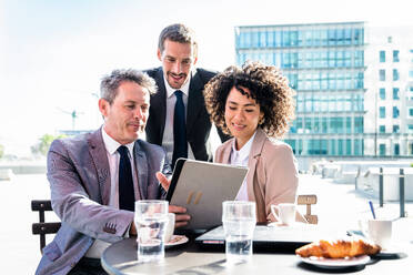 Senior businessman, caucasian man and beautiful hispanic businesswoman meeting in a bar restaurant - Three colleagues bonding in a cafe after work - DMDF01412