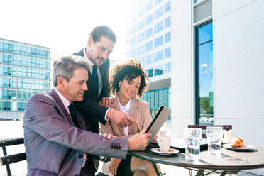 Senior businessman, caucasian man and beautiful hispanic businesswoman meeting in a bar restaurant - Three colleagues bonding in a cafe after work - DMDF01414