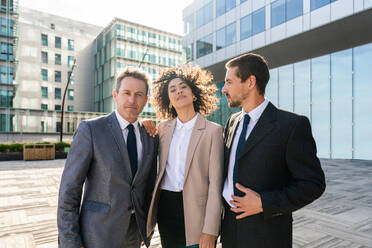 Multiracial group of business people bonding outdoors - International business corporate team wearing elegant suit meeting in a business park - DMDF01431