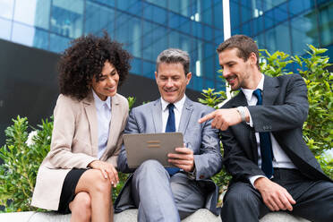 Multiracial group of business people bonding outdoors - International business corporate team wearing elegant suit meeting in a business park - DMDF01443