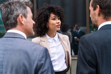 Multiracial group of business people bonding outdoors - International business corporate team wearing elegant suit meeting in a business park - DMDF01449