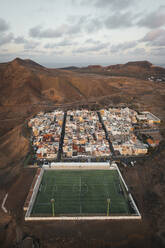 Aerial view of a soccer pitch and a little town, Las Coloradas, Spain. - AAEF19551