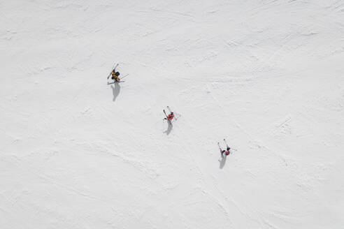 Aerial view of three skiers in a row on Mount Etna, Sicily, Italy. - AAEF19562