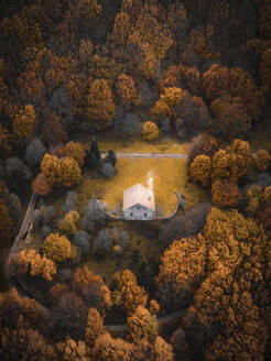 Aerial view of a tiny house surrounded by Colourful trees, Madonie, Sicily, Italy. - AAEF19668