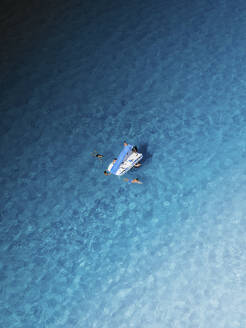 Aerial view of a pedal boat on a crystal clear water, San Vito Lo Capo, Sicily, Italy. - AAEF19686