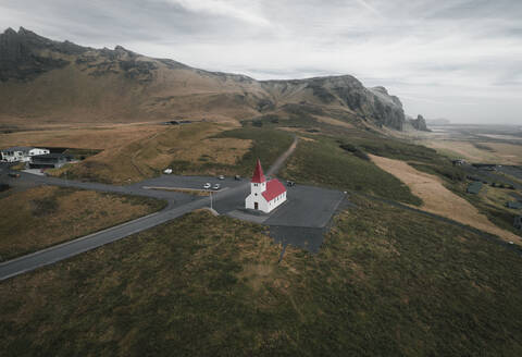 Panoramic aerial view of a church and mountains, Vìk ì Myrdal, Iceland. - AAEF19806