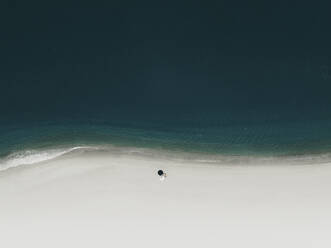 Luftaufnahme eines Sonnenschirms an einem weißen Strand, Sizilien, Italien. - AAEF19833