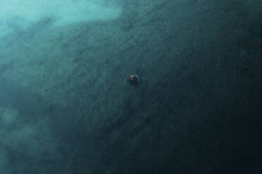 Luftaufnahme einer Person, die auf einer aufblasbaren Matratze schwimmt, Apulien, Italien. - AAEF19874