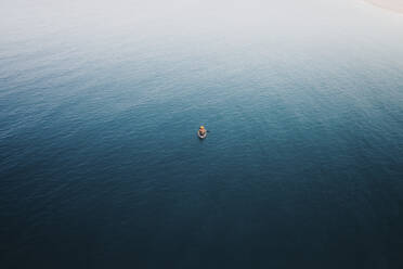 Aerial view of a person doing kayak in open water in Sicily, Italy. - AAEF19888