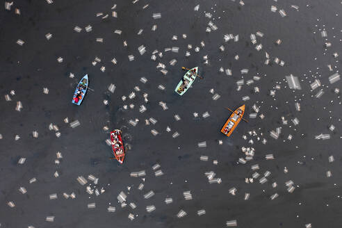 Aerial view of people feeding birds on a fishing boat along the Yamuna river in New Delhi, India. - AAEF19910