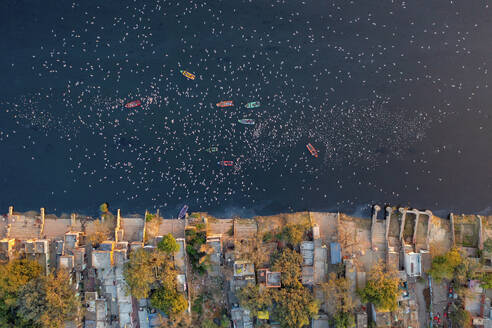 Aerial view of people feeding birds on a fishing boat along the Yamuna river in New Delhi, India. - AAEF19916