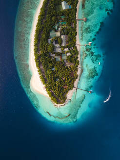 Luftaufnahme eines Bootes am Ende des Piers und der Uferpromenade auf einer Insel im kristallklaren blauen Ozean, Baa Atoll, Malediven. - AAEF20074