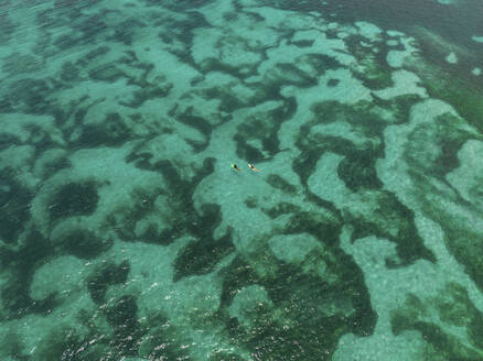 Aerial view of two surfers in Tanjung Aan Beach, Kuta Lombok, Indonesia. - AAEF20109