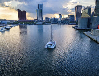 Aerial view of a sailboat at sunset in the Inner Harbor in Baltimore, Maryland, United States. - AAEF20145