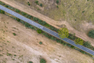 Aerial view of vehicles driving on the road crossing the countryside along the Spanish and Portuguese border, Zebreira, Castel Branco, Portugal. - AAEF20298