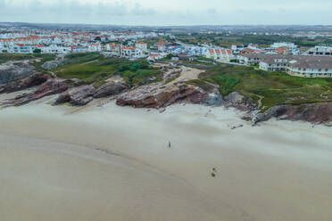 Luftaufnahme von Menschen am Praia Baleal, einem endlosen Strand entlang der Meeresküste bei Sonnenuntergang, Ferrel, Leiria, Portugal. - AAEF20328
