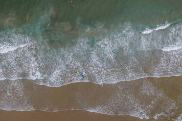 Aerial view of people doing surf in the Atlantic Ocean at Sao Juliao beach, Carvoeira, Lisbon, Portugal. - AAEF20363