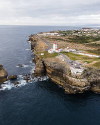 Aerial view of Cabo Carvoeiro lighthouse at sunset along the Atlantic Ocean coastline in Peniche, Leiria, Portugal. - AAEF20378