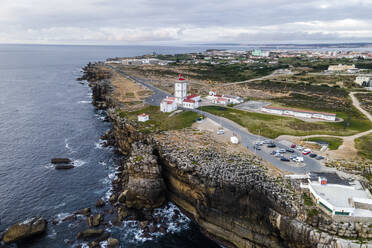 Aerial view of Cabo Carvoeiro lighthouse at sunset along the Atlantic Ocean coastline in Peniche, Leiria, Portugal. - AAEF20381