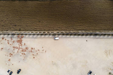 Aerial view of a camper van parking in a parking lot in Obidos near the agricultural fields, Portugal. - AAEF20429