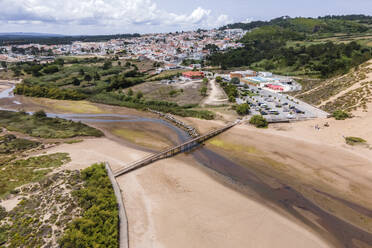Aerial view of a walking bridge crossing Praia de Salir do Porto beach along Baia de Sao Martinho do Porto, a small bay along the coast in Portugal. - AAEF20435