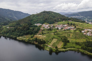 Aerial view of a small village along the Minho river in Val de Pereira, Ourense, Spain. - AAEF20476