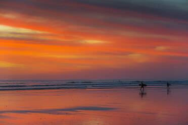 Surfer silhouetted on Guiones Beach where many come to relax and surf at sunset, Playa Guiones, Nosara, Guanacaste, Costa Rica, Central America - RHPLF26060