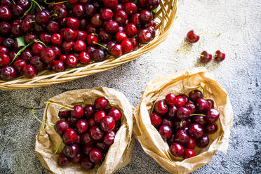Red organic cherries in baskets ready to eat from above, Italy, Europe - RHPLF26099
