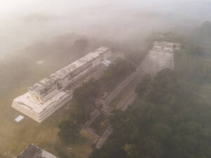 Aerial view of the ancient city of Uxmal with mist, an archeological site in Yucatan, Mexico. - AAEF20595