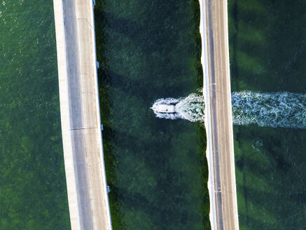 Aerial view of a speedboat sailing under the bridge in Progreso, Yucatan, Mexico. - AAEF20609