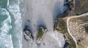 Aerial view of people on the beach with rocks along the shoreline near Ribadeo, Lugo, Spain. - AAEF20666