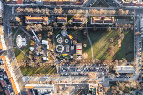 Aerial view of a theme park with Ferris wheel at Trg Franje Tudjmana park at sunset in Zagreb downtown, Croatia. - AAEF20695