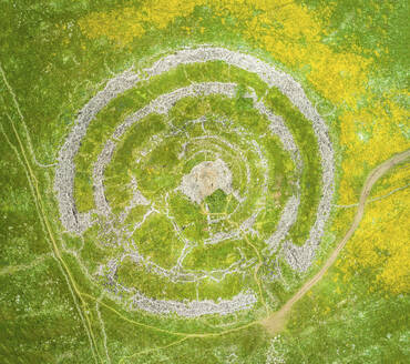 Aerial view of ancient megalithic monument in the shape of concentric stone circles in an open grassland, Rujum Al-Hiri, Golan Heights, Israel. - AAEF20749