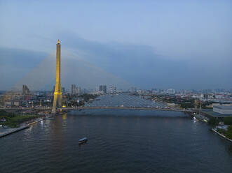 Aerial view of The Rama VIII Bridge, a cable-stayed bridge crossing the Chao Phraya River at night in Bangkok, Thailand. - AAEF20862